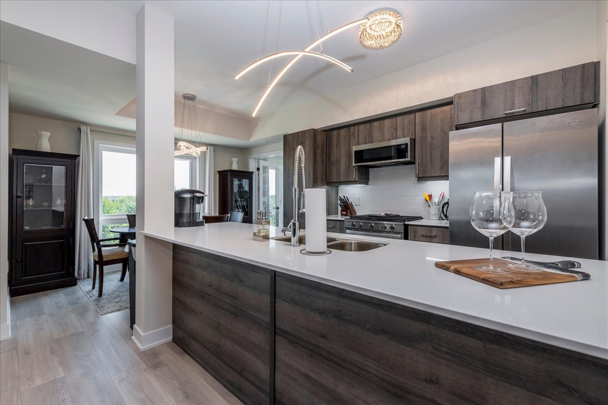 Kitchen with island, quartz counters, and stainless steel appliances at 301 - 8 Culinary Lane, Barrie